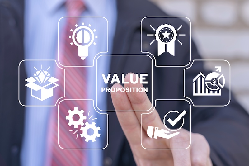 A person in a suit points at a transparent screen displaying "VALUE PROPOSITION," surrounded by icons—ideas, rewards, growth, settings, a checkmark, and a package—illustrating reputation theory in strategic business decisions.