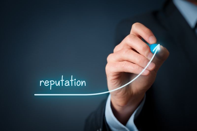 A person in a suit draws an upward curved arrow with the word "reputation," symbolizing how to keep a good reputation and achieve steady growth or improvement, against a dark background.