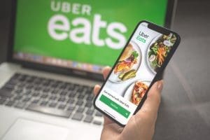 A person holding a phone with the uber eats app on it.