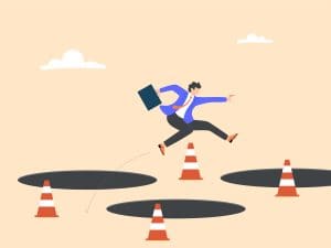 Illustration of a businessperson in a suit jumping over large holes and traffic cones, holding a briefcase, symbolizing overcoming obstacles or challenges in a professional setting.