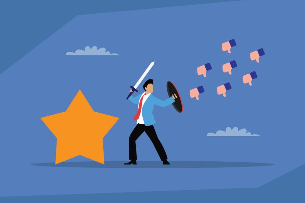 Illustration of a person in business attire holding a sword and shield, standing in front of a large gold star, defending against multiple thumbs-down icons on a blue background.