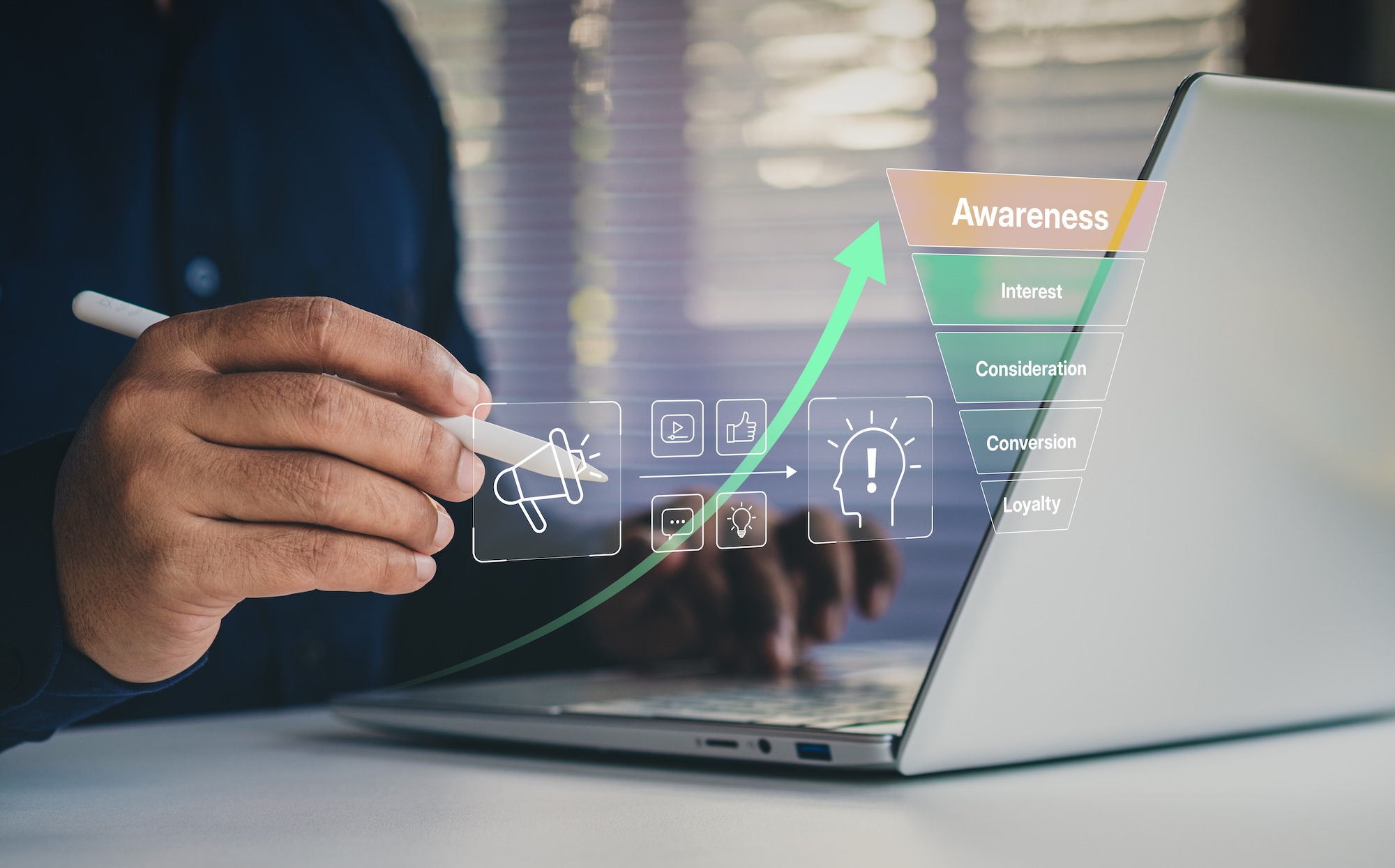 A person sits at a laptop and is raising brand awareness as indicated by the chart on the screen.