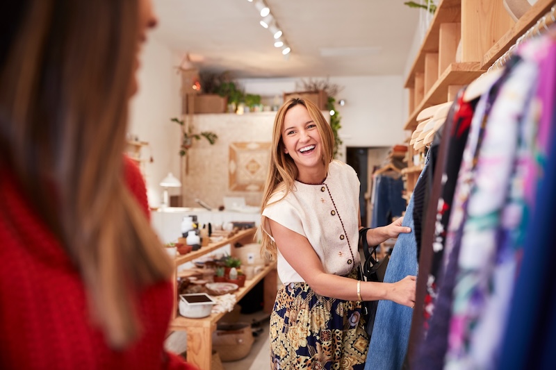 Two people are shopping in a retail store and laughing.